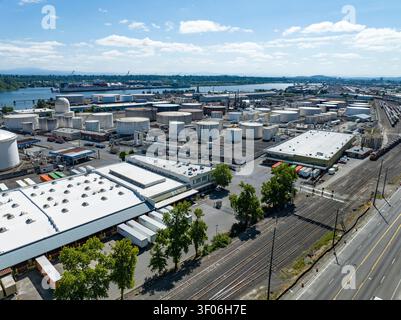 Eine Luftpanoramablick offenbart ein weitläufiges Petroleum- und Chemikalienlager neben einem geschäftigen industriellen Flusshafen im Pazifischen Nordwesten. Stockfoto