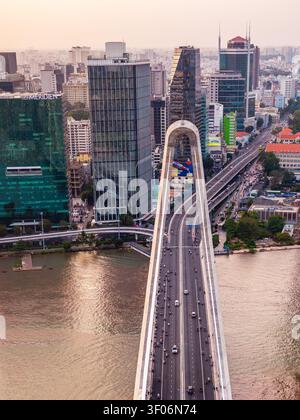 Blick aus der Vogelperspektive auf die Thu Thiem Bridge mit dem Verkehr, der über den Saigon River fließt, umgeben von modernen Wolkenkratzern und Stadtentwicklung in Ho Chi Minh City Stockfoto