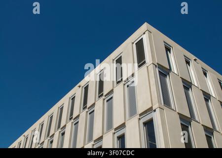 Niedrigwinklige Perspektive der modernen Campus-Est-Gebäudefassade mit geometrischen Gitterfenstern und Betonplatten. Zeitgenössische Architektur Stockfoto