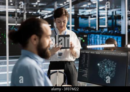 Der Rechenzentrumsadministrator verwendet ein Tablet, um die Serversoftware zu aktualisieren und so zuverlässige Infrastrukturbetriebe zu unterstützen. Stockfoto