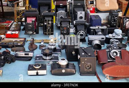 XALO, SPANIEN - 20. JUNI 2026. Eine Hochwinkelaufnahme zeigt einen Marktstand, der mit vielen Analogkameras aus der Mitte des Jahrhunderts, antiken Objektiven und Vintage-Leder gefüllt ist Stockfoto
