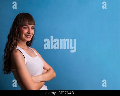 Selbstbewusste junge Frau, die mit gekreuzten Armen lächelt Stockfoto