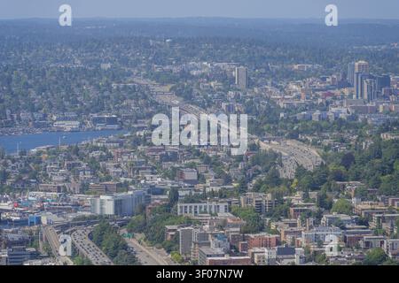 Eine hohe Luftaufnahme fängt eine weitläufige urbane Landschaft mit einer stark frequentierten Autobahn, dichten Wohngebieten und einer Uferpromenade ein. Stockfoto