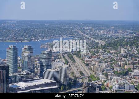 Ein erhöhter Blick auf Seattle mit modernen Wolkenkratzern, einem verkehrsreichen mehrspurigen Highway und Lake Union, umgeben von städtischer Entwicklung. Stockfoto