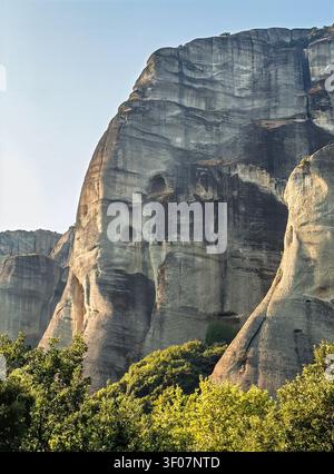 Kalambaka, Griechenland - 24. Juli 2024: Meteora-Gruppe von Klöstern. Einer der steilen Felshänge und Klippen. 2 Höhlenöffnungen sichtbar Stockfoto