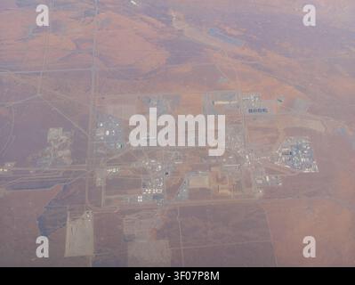 Hochwinkelansicht einer großen Industrieanlage mit Lagertanks und Gebäuden in einer trockenen, rötlich-braunen Landschaft. Stockfoto