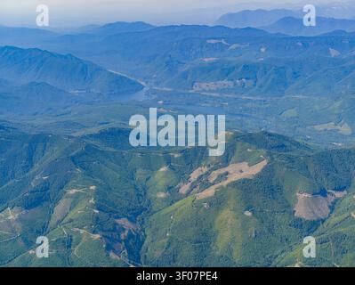 Aus der Vogelperspektive auf sanfte grüne Berge und ein sich windendes blaues Reservoir in der Landschaft des pazifischen Nordwestens. Stockfoto