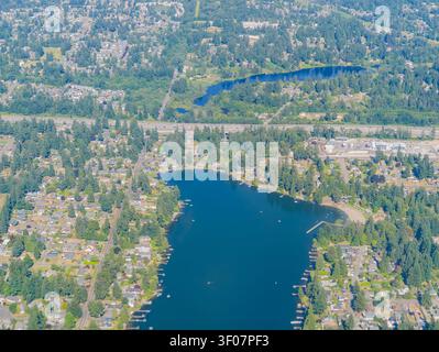 Blick auf einen blauen See, umgeben von Häusern, Bäumen und einer Autobahn in einem Vorstadtgebiet des Bundesstaates Washington. Stockfoto