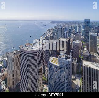 Die Skyline von Seattle, das Columbia Center und die Uferpromenade mit Fähren auf dem Wasser unter einem klaren blauen Himmel sind aus der Vogelperspektive zu sehen. Stockfoto