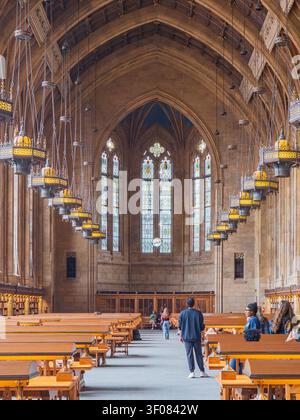 Washington State, USA, 26. Juni 2026 - Besucher spazieren durch den großen gotischen Lesesaal der Suzzallo Library mit Holzbänken und Stockfoto