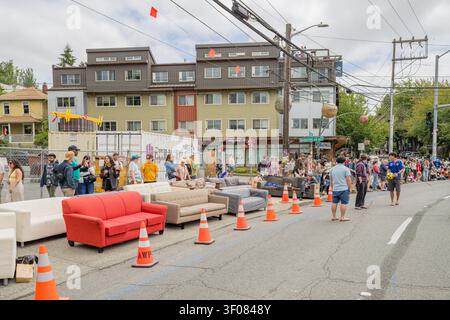 Washington State, USA, 20. Juni 2026 - Reihen von Sofas und orangefarbenen Verkehrskegeln säumen eine Stadtstraße, während die Zuschauer die Fremont Solstice beobachten Stockfoto