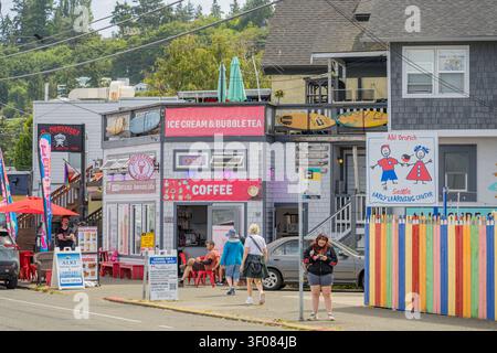 Washington Staat, Vereinigte Staaten, 21. JUN 2026 - Straßenansicht des Alki Branch Early Learning Center und einer Eisdiele mit Passanten, die auf der Stockfoto