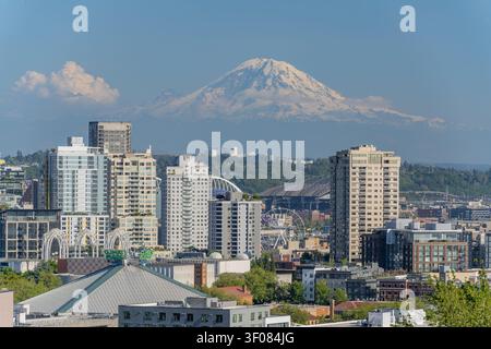 Washington Bundesstaat, Vereinigte Staaten, 21. JUNI 2026 - Eine Ansicht der Stadtlandschaft von Seattle mit Hochhäusern, einem Riesenrad und dem schneebedeckten Stockfoto