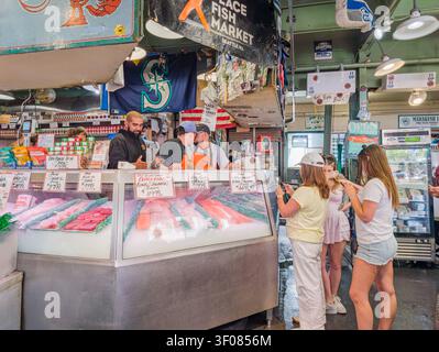 Washington State, USA, 21. Juni 2026 – an einem belebten Fischmarkt in Seattle, Washington, können Besucher frischen Lachs und Meeresfrüchte auf Eis genießen. Stockfoto