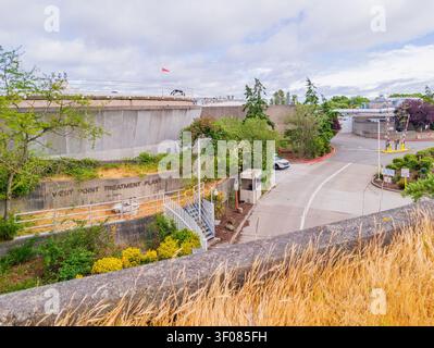 Washington Bundesstaat, Vereinigte Staaten, 26. JUN 2026 - Betonwände und Zufahrtsstraße der West Point Treatment Plant im Washington Bundesstaat mit Grün Stockfoto