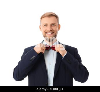 Ein lächelnder Mann, der die rote Schleife in der Anzugsjacke anpasst Stockfoto