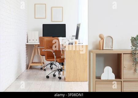 Moderner minimalistischer Büroarbeitsplatz mit Computern und Stühlen Stockfoto