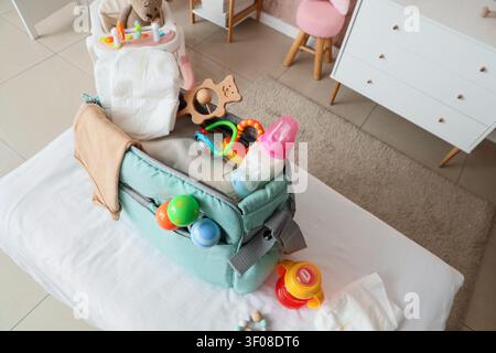 Babytasche mit Zubehör auf Wickeltisch im Kinderzimmer, Draufsicht Stockfoto