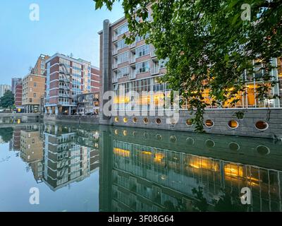 Moderner Wohngebäude, der sich in einem Kanal in Rotterdam, Südholland, Niederlande, spiegelt. Stockfoto