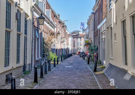 Schmale Kopfsteinpflasterstraße, gesäumt von historischen Häusern im Zentrum von Utrecht, Niederlande. Stockfoto