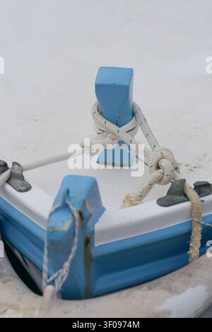sicher befestigtes Seil auf einem Bootdeck, Nahaufnahme-Perspektive, die praktische Bootsausrüstung im Kontext von Marinezubehör mit blauen und weißen Farben zeigt Stockfoto