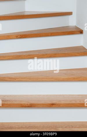 Holztreppe ohne Handlung, in einem Innenraum, wahrscheinlich in einem Wohn- oder Bürogebäude, mit Holztreppen, weißer Wand, mit Holz, gestrichener Wand Stockfoto