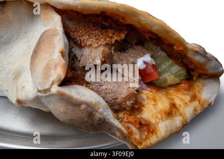 Frisch zubereiteter türkischer Lahmacun gefüllt mit gewürzter Doner-Fleisch, mit einer knusprigen dünnen Kruste und authentischem Street-Food-Aroma, perfekt für Essen, r Stockfoto