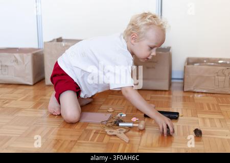 Kleinkind sammelt natürliche Objekte und übt dabei Haushaltsrecycling. Praxisnahe Aktivitäten verbinden Natur mit nachhaltigem Leben. Stockfoto