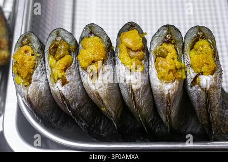 Gesalzenes getrocknetes Schlangenhaut-Gurami mit Rogen, präsentiert auf einem Marktteller an einem traditionellen thailändischen Frischmarkt, konservierter Süßwasserfisch zum Kochen. Stockfoto