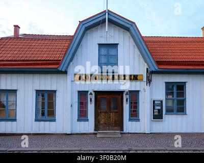 Vimmerby, Schweden - 07.06.2026: Historische Holzfassade mit dem Komedianten-Theaterschild, blauen Fensterrahmen und Terrakotta-Dachziegeln Stockfoto