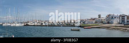 CALASETTA, 2026 1. Mai; redaktionelle Panorama-Stadtansicht mit Booten, die im Hafen festgemacht sind, und wenigen Menschen am Ufer des historischen, touristischen Dorfes an der Meeresküste Stockfoto