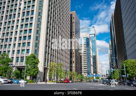 Weitwinkelaufnahme des Geschäftsviertels Marunouchi mit modernen Wolkenkratzern, breiten Boulevards und zeitgenössischen Bürogebäuden unter einem blauen Himmel Stockfoto