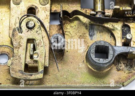 Extreme Makro-Nahaufnahme, die den komplexen inneren Mechanismus eines antiken Messing-Türschlosses mit kunstvollen Federn und Metallverriegelungen offenbart Stockfoto