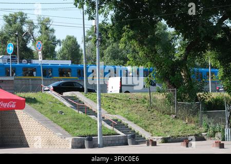 Kiew, Ukraine - 7. Juli 2026: Ein Kiewer Metrozug fährt auf einem Freiluftabschnitt der Metrostrecke in der Nähe der Hydropark-Station an einem sonnigen Sommertag in der Stockfoto