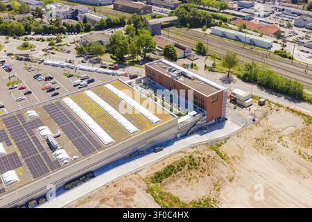 Luftaufnahme eines weitläufigen Industriegebiets mit Parkplatz und Bahngleisen, PV-Anlage bei OBI Baumarkt, Mühlacker, Enzkreis, Deutschland Stockfoto