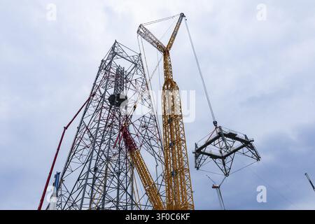 Montage des letzten Turmsegments auf dem GICON-Höhenwindturm, sodass der Turm eine Höhe von 157 m erreicht. Die weltweit größte Windturbine Stockfoto