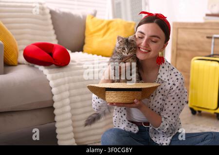Frau hält Hut mit süßer Katze zu Hause. Platz für Text Stockfoto