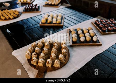 Elegante Auswahl an Gebäckstücken auf Holztablettauslage Stockfoto