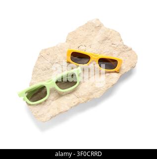 Gelbe und grüne Sonnenbrille auf einer Steinplatte Stockfoto