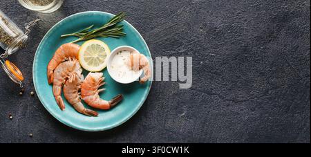 Gekochte Garnelen mit Zitrone und Sauce auf blauem Teller Stockfoto