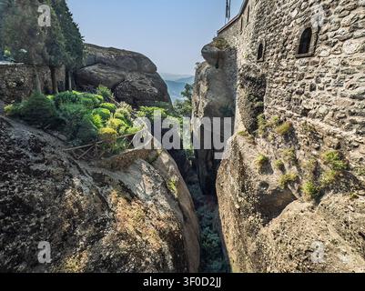 Kalambaka, Griechenland – 24. Juli 2024: Meteora, Kloster Sankt Stefan: Schlucht zwischen dem Kloster und dem nächsten Felsplateau mit dem Weg hinein Stockfoto