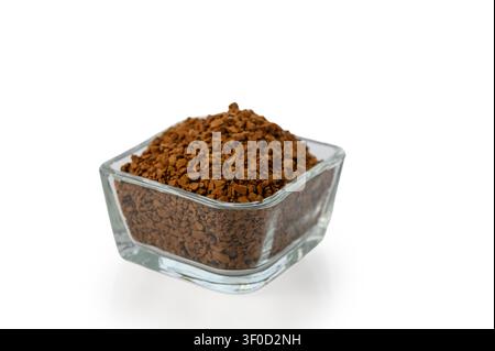 Eine Nahaufnahme, hochwinklige Studioaufnahme von Instantkaffegranulat, serviert in einer kleinen quadratischen Glasschale, isoliert auf einem sauberen weißen Hintergrund. Stockfoto