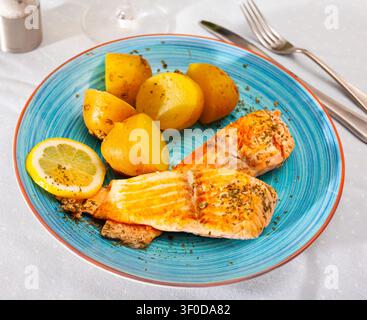 Gebratenes Lachsfilet mit gekochten Kartoffeln in Schale Stockfoto
