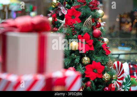 Weihnachtsgeschenke neben einem schön geschmückten Weihnachtsbaum. Konzept der Feiertagssaison. Stockfoto