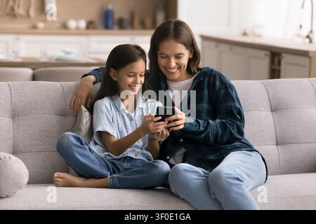 Mutter und Kind verwenden ein Smartphone, spielen Spiele, schauen amüsante Videos Stockfoto