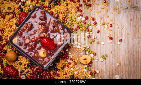 Traditioneller chinesischer Congee mit gemischten Bohnen und Getreide auf einem Holztisch Stockfoto
