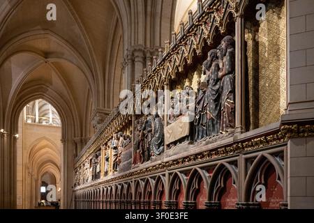 Langwierige Perspektive des vergoldeten Chorgitters in der Notre Dame de Paris, das gotische Bögen, heilige Skulpturen und das historische Kircheninnere hervorhebt. Stockfoto