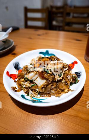 Char Kway Teow malaysische gebratene Flachreisnudeln mit Garnelen und Ei auf einem traditionellen Teller Stockfoto
