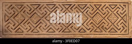 Nahaufnahme eines geschnitzten Steinreliefs mit geometrischem Flechtmuster, das im Bode-Museum in Berlin, Deutschland, ausgestellt ist. Stockfoto