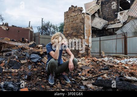 Vyshneve, Oblast Kiew, Ukraine - 6. Juli 2026: Ein Anwohner sitzt inmitten von verbrannten Trümmern und Überresten einer Wohngebäude, die nach einem Raketenangriff zerstört wurden Stockfoto